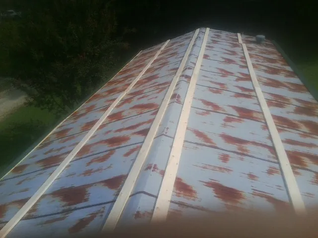 Rusted metal roof panels with new wood purlins before replacement — Storm Damage Roof Repair in Masontown by Roofing Brothers