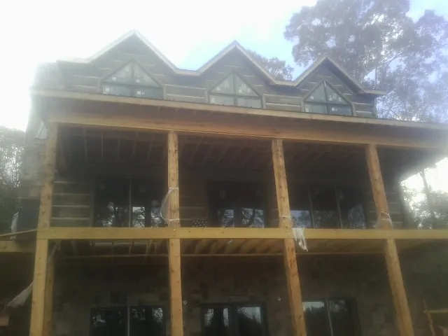 Dormers and porch framing on a large log home under construction — Roof Coating work by our crew in Masontown