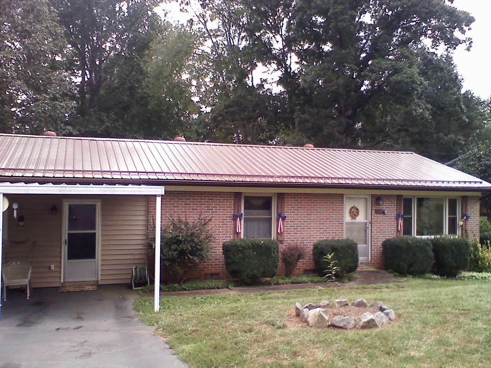 Bronze metal roof and carport on a brick ranch home — Roof Repair work by our crew in Masontown